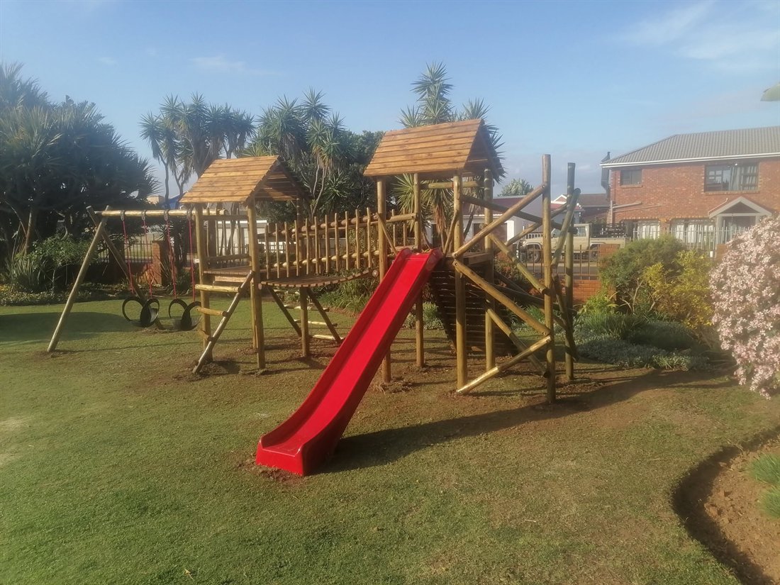 Pole jungle gym with red slide and swings